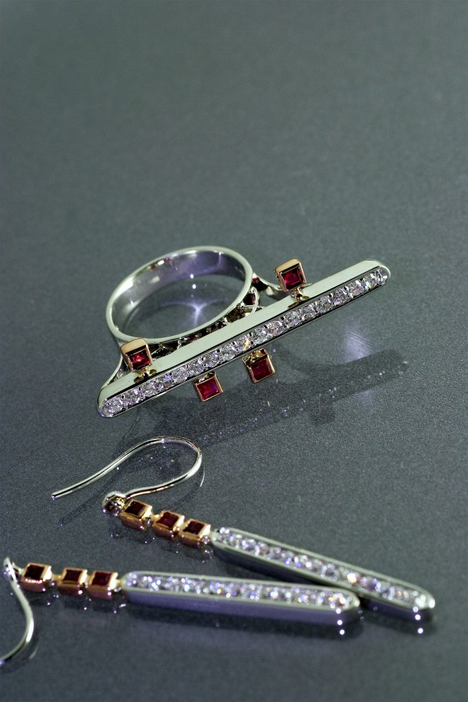 ellipse bridge ring er in rubies set in rose gold and white gold with pave diamonds